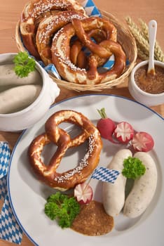 White sausage breakfast with sausages,pretzels and sweet mustard on wood substrate