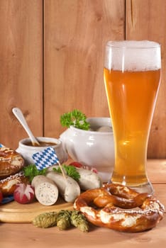 White sausage breakfast with sausages,pretzels,white beer and sweet mustard on wood substrate