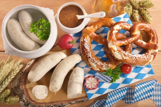 White sausage breakfast with sausages,pretzels,white beer and sweet mustard on wood substrate