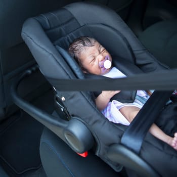 A newborn baby girl in a car seat.