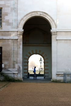 London,United Kingdom – November 29,2014: A passer-by walks past a circular arch entrance at the Royal Naval College in Greenwich on November 29,2014 in London.