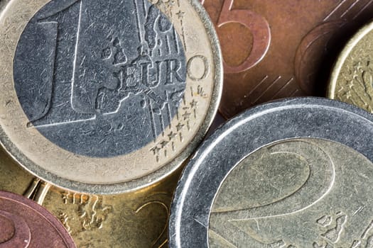 Euro Coins on Top of Each Other with the one Euro and the 2 Euro being most prominent.