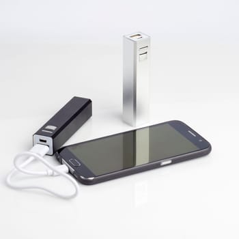 Charging a smartphone from powerbank on white table