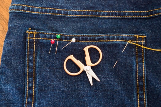 Needle with a thread through the jean, stock photo