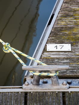 Close-up of a receipt lamp with suspended rope on a jetty with the number 17