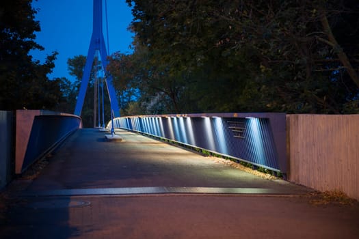 perspective view over pedestrian bridge Hoher Bogen over the Stadt-Autobahn in Berlin at night in the moonlight