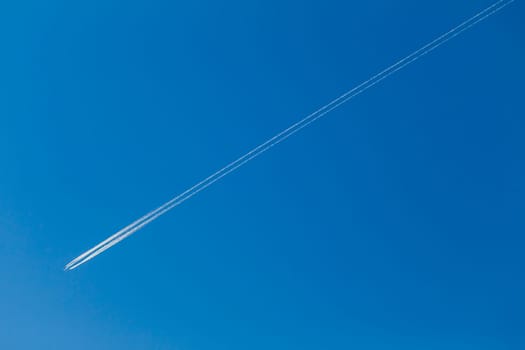 Jet Plane flying vapor white trail afternoon blue sky