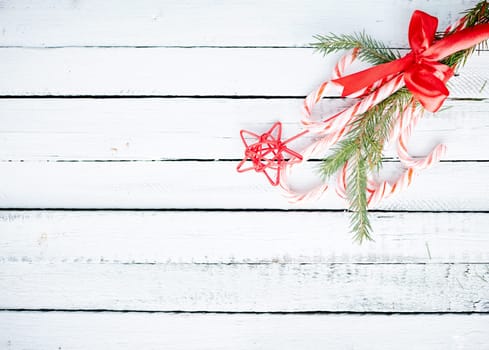 Christmas bouquet made up of candy canes, red star and conifer branches over wooden background