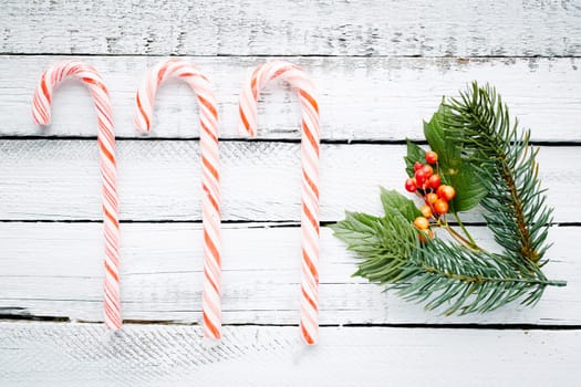Cane candies, conifer and guelder over wooden background
