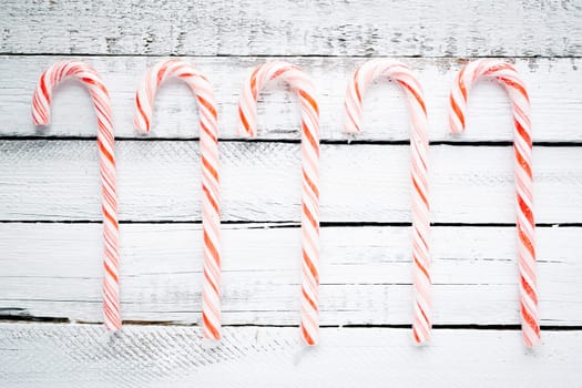 Several sweet canes over wooden background