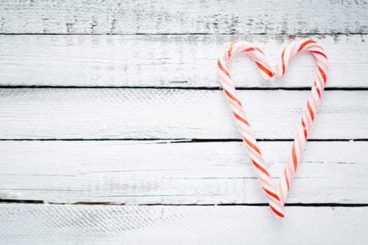 Candy cane heart on wooden background