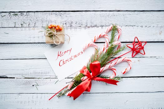 Christmas bouquet, greeting card and small giftbox on wooden background