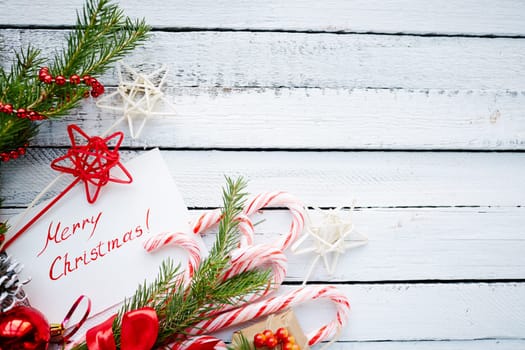 Christmas decorations and greeting card on wooden background