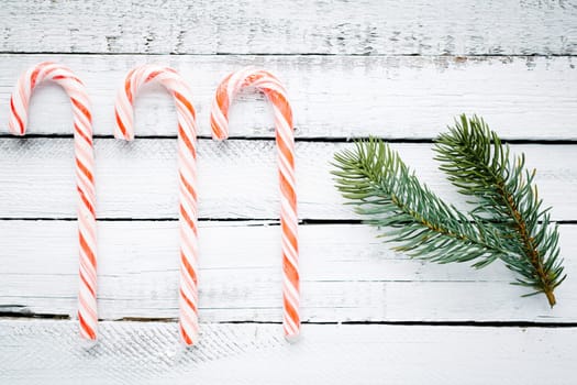 Candy canes and conifer over wooden background