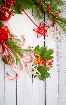 Traditional Christmas sweets and decorations on white wooden background