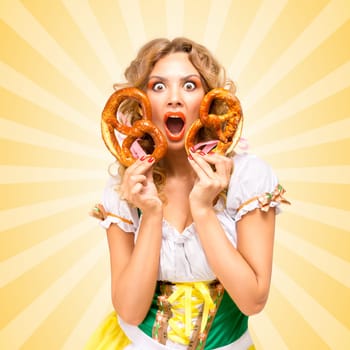 Beautiful embarrassed sexy Oktoberfest woman wearing a traditional Bavarian dress dirndl holding two pretzels on colorful abstract cartoon style background.
