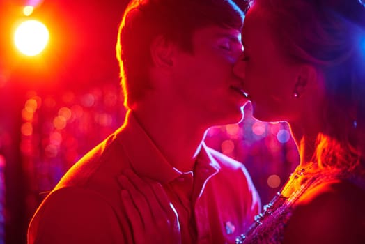 Romantic couple kissing in night club