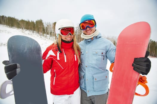 Couple of affectionate snowboarders enjoying vacation on winter resort