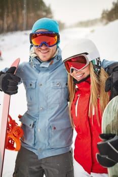 Couple of young snowboarders enjoying their winter vacation