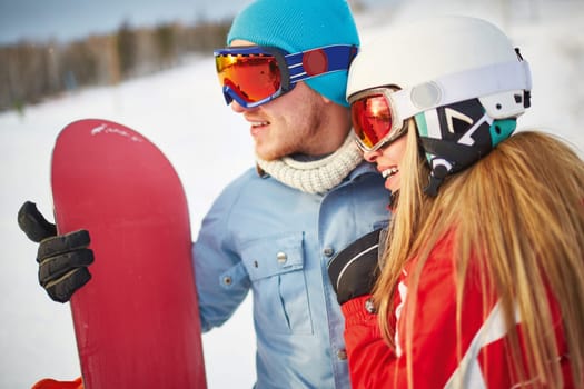 Amorous snowboarders in winter activewear spending vacation at sportive resort