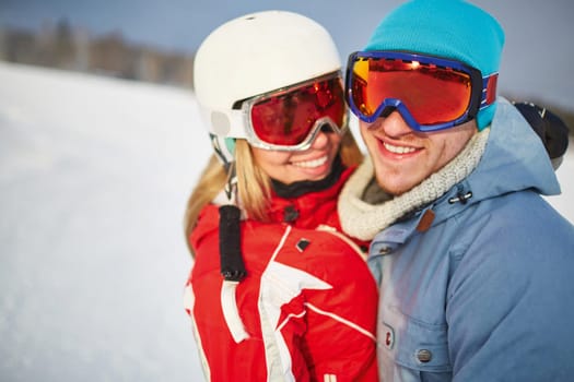 Young dates in winter sportswear and goggles looking at camera in natural environment