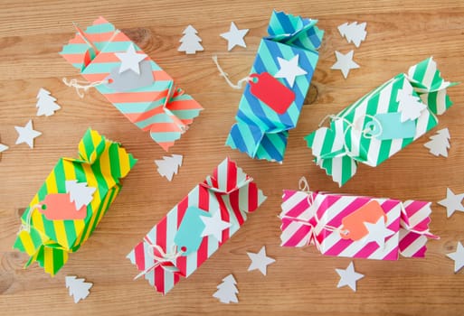 Small colorful gifts for Christmas on rustic background made of wood