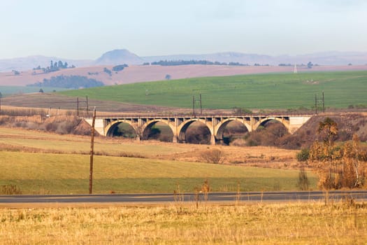 Rural farming fields alongside railway train bridge road scenic landscape