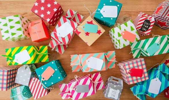 Small colorful gifts for Christmas on rustic background made of wood