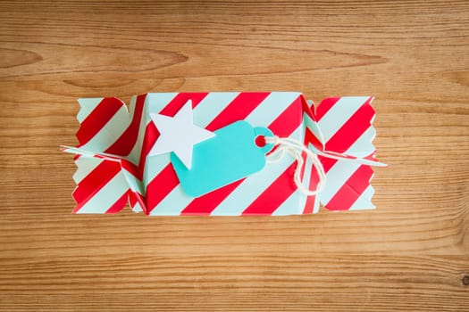 Small colorful gift for Christmas on rustic background made of wood