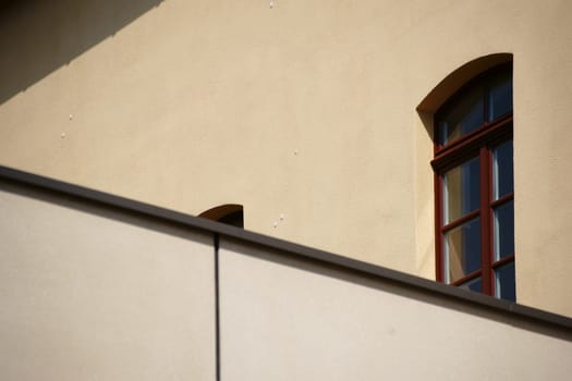 A roof edge with a facade behind it of a building with windows.