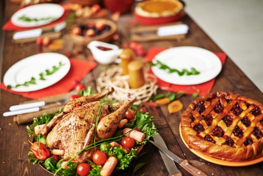 Homemade pie and roasted chicken on served Thanksgiving table