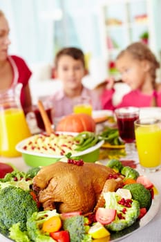 Homemade roasted turkey surrounded with vegetables on served table
