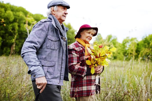 Elderly couple spending time in park in autumn