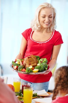 Happy young woman with roasted Thanksgiving turkey