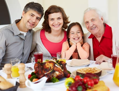 Happy family sitting at celebration table on Thanksgiving Day