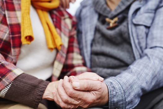 Hands of senior man and woman in warm clothes