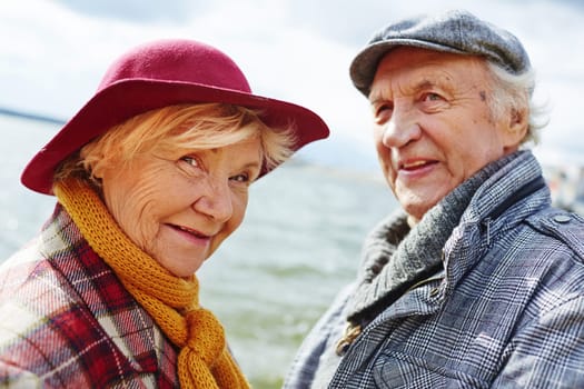 Retired female looking at camera with her husband on background