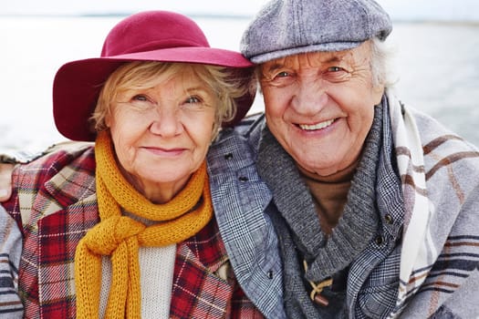 Retired couple in warm clothes looking at camera