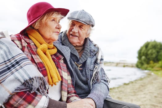 Retired couple in warm clothes having outdoor rest