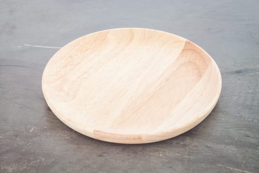 Wooden plate on grey background, stock photo