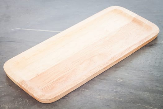 Wooden plate on grey background, stock photo