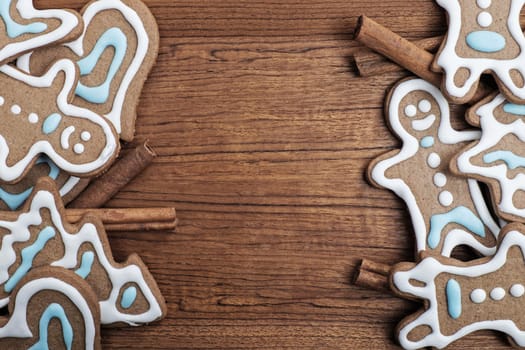 Gingerbread cookies with cinnamon sticks on a wooden background