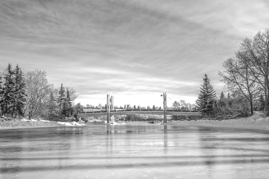 Monochrome winter landscape of a skating rink and the Jaipur Bridge, Calgary, Alberta.