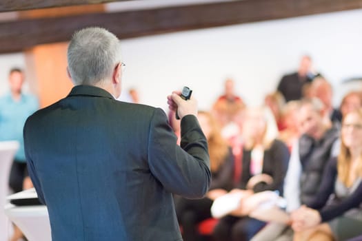 Speaker at Business Conference with Public Presentations. Audience at the conference hall. Entrepreneurship club. Rear view. Horisontal composition. Background blur.