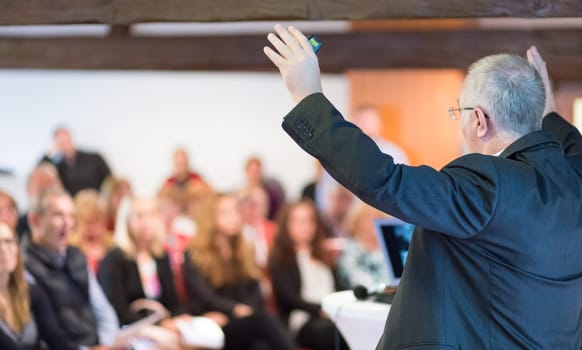 Speaker at Business Conference with Public Presentations. Audience at the conference hall. Rear view. Horisontal composition. Background blur.