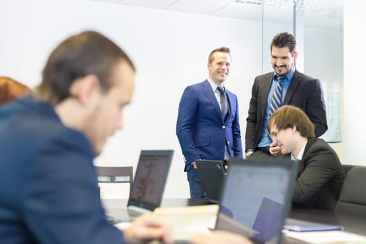 Workplace in modern office with business people brainstorming. Businessman working on laptop during the meeting. Business and entrepreneurship concept.