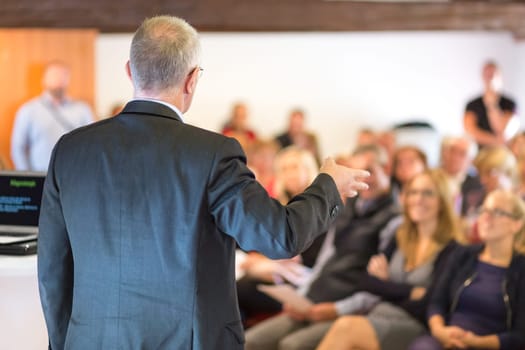 Business man leading a business workshop. Corporate executive delivering a presentation to his colleagues during meeting or in-house business training. Business and entrepreneurship concept.
