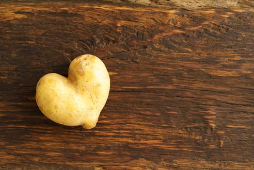 Heart-shaped potato on dark wood