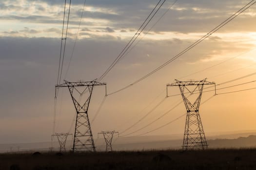 Powerlines electrical cables tower structures stretch over rural countryside
