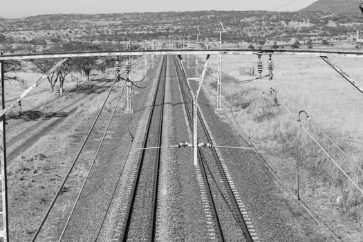Railway train tracks line travel through dry season rural landscape